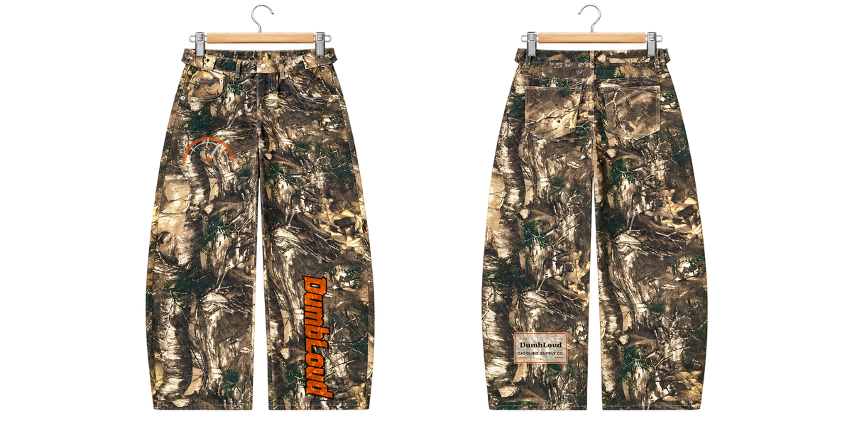 DumbLoud Tree Camo Gas Pants on metal clip hanger